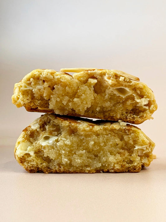 Almond Croissant cookie cut in half on a beige background